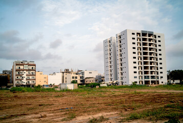 Fototapeta na wymiar Un terrain vague avec des immeubles en construction au fond vers l'ancien aéroport de Dakar au Sénégal en Afrique