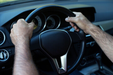 Car interior with a driver. Hands on a steering wheel. Driving a car wallpaper