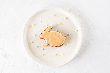 Homemade gingerbread in the form of a rabbit with aquafaba glaze in a plate. Gluten, lactose and sugar free.
