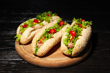 Hot dogs on board on wooden background, close up