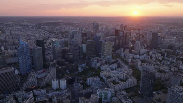 Aerial panoramic view of modern business district with high rise office buildings. Famous La Defense against romantic sunset sky. Paris, France