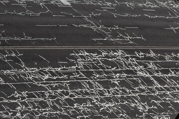 Cracks in the road surface of a multi-lane highway are filled with squiggly tar (resin). Asphalt road after repair