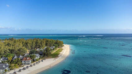 Le Morne tropical beach and famous kite, surf spot aerial panoramic view with palm trees and white sand blue ocean and sunbeds with umbrellas, Mauritius