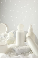 Cosmetic jars and snow on white background, space for text