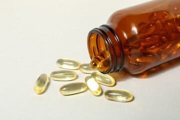 Brown bottle with omega pills on white background