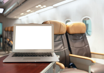 Laptop blank screen in luxury passenger flight cabin business economy class background for transport technology graphics design element.
