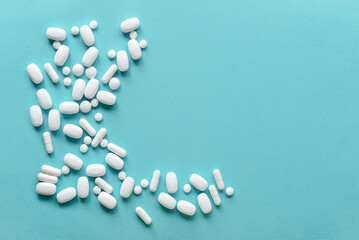 White pills on blue background. Mock up for special offers as advertising, web background or other ideas. Medical and healthcare concept. Copy space. Empty space for text or logo