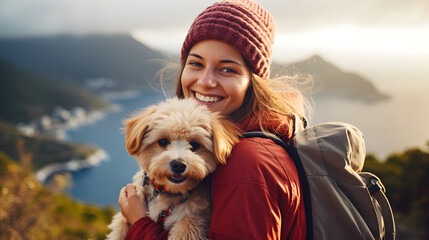 Beautiful smiling tourist woman holding her dog at view point of mountain