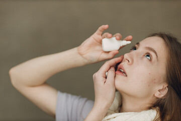 Young woman has flu catarrh ill sick disease treatment cold hold medicine eye spray