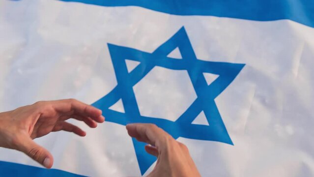 Hand in heart shape on Israel flag