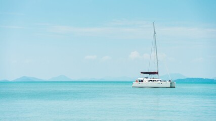 Tranquil blue sea with a cruise boat in clear weather in Phang Nga Bay, Phuket, Thailand. © Wirestock
