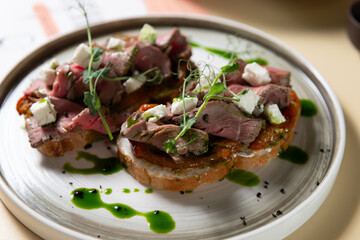 pork and cheese on bread with greens