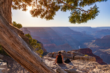 The girl relaxes at sunset over the Grand Canyon in the USA