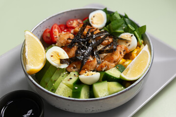 chicken bowl, healthy meal with avocado on pale green background