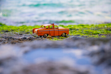 Model yellow taxi left on the beach