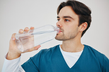 Nurse, man drinking water in bottle and health, wellness or body nutrition in studio isolated on a...