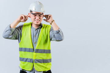 Young engineer covering ears isolated. Engineer man with ear pain. Concept of engineer covering his...