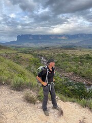 Fototapeta na wymiar Male hiker with backpack and Tepui Roraima in the background, Canaima National Park, Venezuela, South Americain 