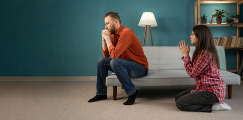 Young wife asking forgiveness, making peace with offended husband after quarrel. Family crisis,...