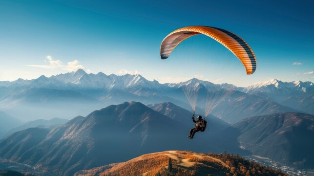 Paraglider flying in the beautiful valley between mountains