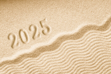 Imprints of numbers 2025 happy new year on a golden sand waves