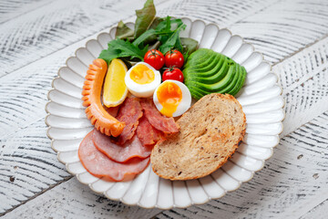 Breakfast: toast, avocado, boiled eggs, ham, bacon and sausage