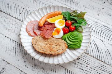 Breakfast: toast, avocado, boiled eggs, ham, bacon and sausage
