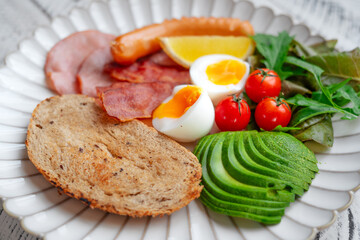 Breakfast: toast, avocado, boiled eggs, ham, bacon and sausage