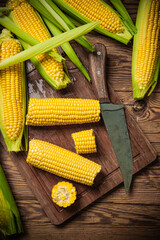Fresh corn on wooden table.