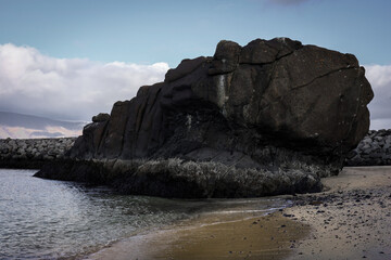 Big black volcanic rock on Skarfaklettur beach in Reykjavik, Iceland. 