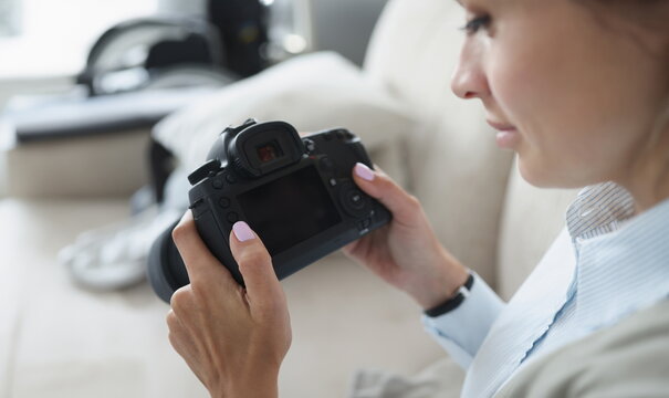 Woman holds black professional camera in her hands. How to become professional photographer yourself from scratch concept