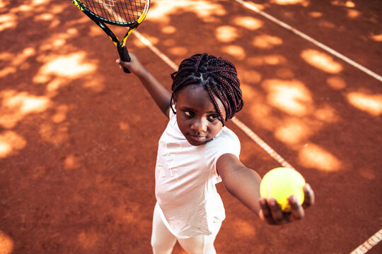 Young Girl Practicing Her Serve On A Outdoor Clay Tennis Court