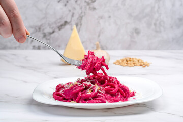 Cooked Barbie pasta on a fork over a white plate with pasta.