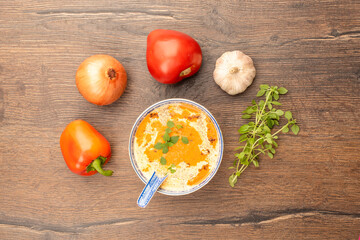 A plate of soup with pureed tomatoes, peppers, onions and garlic, cream and green basil.