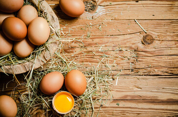 Chicken eggs in a plate on wooden table.