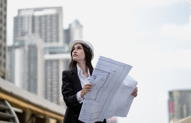 Estate architect working on real estate structure engineering in urban. Female property development engineer reading blueprint, plan skyscraper layout. Beautiful woman designer plan apartment project.