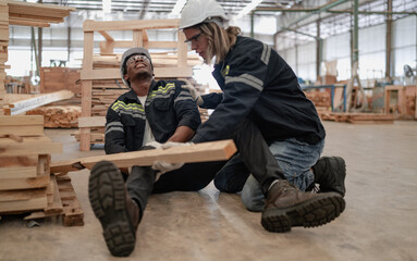 Foreman injured from accident lying on floor crying with pain in warehouse. Female worker emergency help male colleague who falling down get physical injury in workplace. Risk, dangerous in workplace