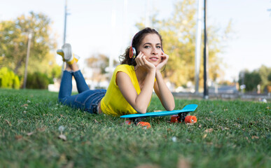 Young modern woman outdoors in the city, with skateboard
