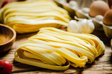 Homemade pasta tagliatelle. On wooden table.