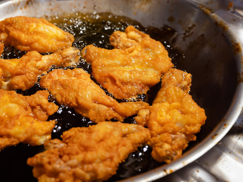 Close - Up Of Chicken Wings On A Frying Pan