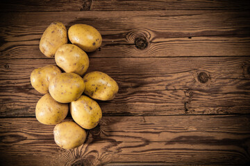 Fresh potatoes. On wooden table.