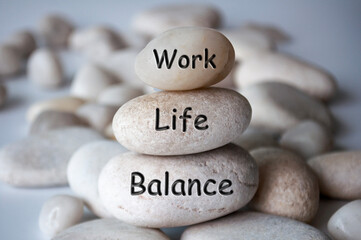 Work life balance text engraved on white stones. New ways of working concept. - obrazy, fototapety, plakaty