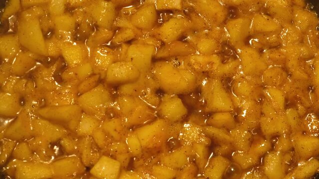 Cooking apple in a frying pan. Fried apples with honey sugar, fall side dish. Glazed cinnamon Apple Fritter Skillet. Caramel. Homemade autumn sweet dessert. Ingredients for crumble, tart, crisp or pie