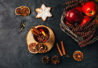 close-up of a glass with mulled wine cinnamon and cardamom on a black background with ingredients...
