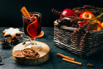 close-up of a glass with mulled wine cinnamon and cardamom on a black background with ingredients...