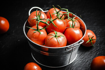 Fresh tomatoes. On black table.