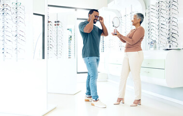 Mirror, glasses and optician help happy man in store for choice of lens, frame and consultation. Smile, reflection and mature optometrist with patient for spectacles, healthy vision and ophthalmology - obrazy, fototapety, plakaty