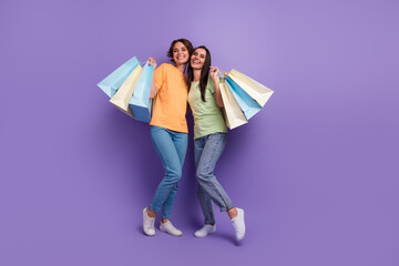 Full length cadre of of optimistic young girls spend weekend italian fashion week shopping hobby...