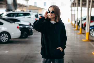 Fototapeta premium Young woman in glasses and black hoodie
