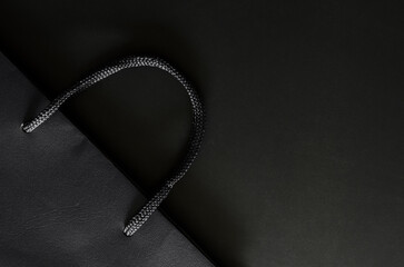Black shopping paper bag on black backgrond for Black Friday shopping sale concept.